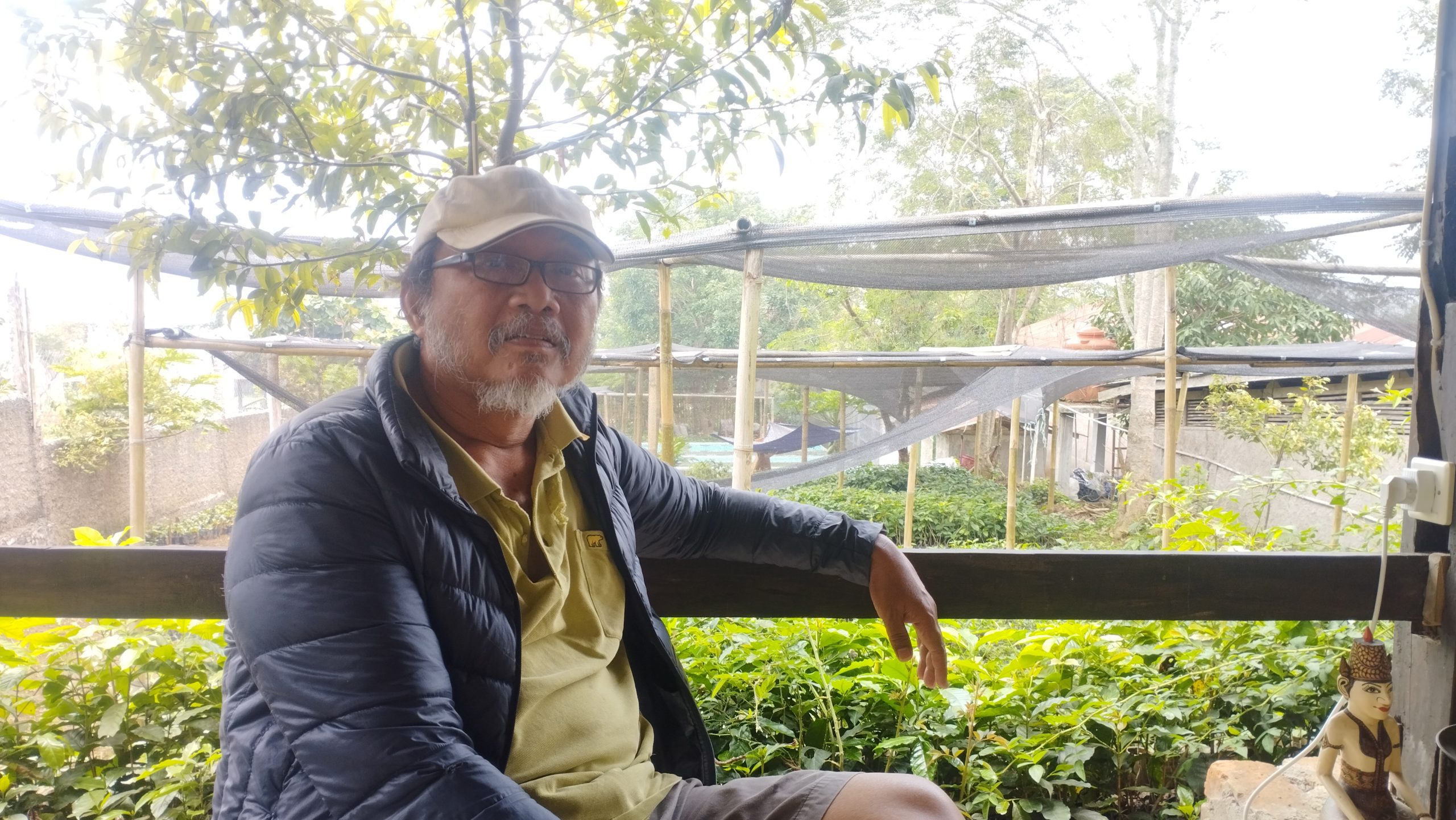 Tosca Santoso, salah satu petani kopi di Desa Ciputri. Di belakangnya, tampak sejumlah bibit alpukat dan pohon-pohon endemik. (Dok. Wahyu/Progresip)